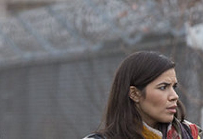 Four women, including America Ferrera, stand in a line across from a coal plant.